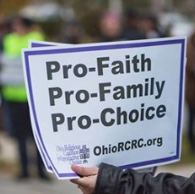 Hand holding a sign that says Pro Faith, pro-family, pro-choice