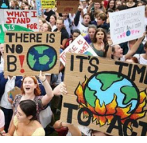 Lots of people outside from a view above all holding signs like There is no planet B and It's time to Act