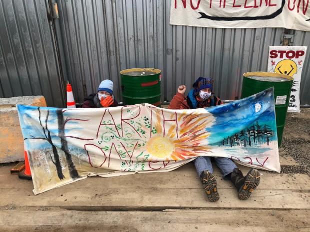 People sitting and holding an Earth Day banner