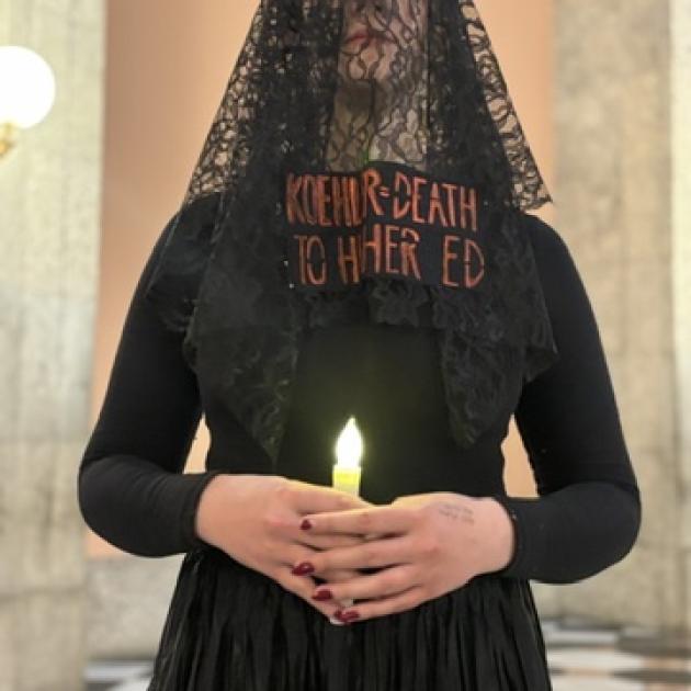 Woman in funeral clothes with a candle