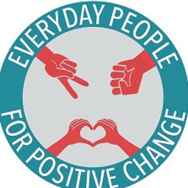 Round blue circle with words everyday people for positive change going around inside a ring in white letters, inside the circle a red hand doing a peace sign, a red hand making and fist and two red hands creating a heart with their fingers together