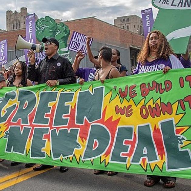 Banner that says Green New Deal and people marching