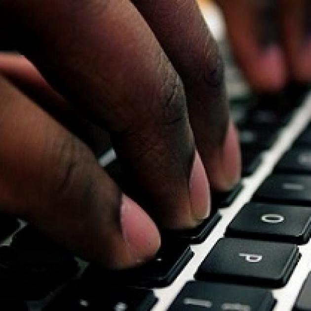 Close up of someone's fingers typing on a computer keyboard