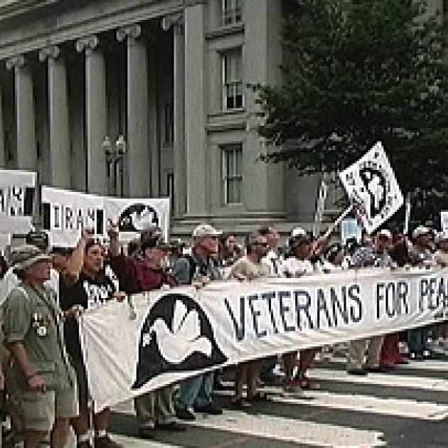 People holding a banner that says Veterans for Peace standing in front of a government building