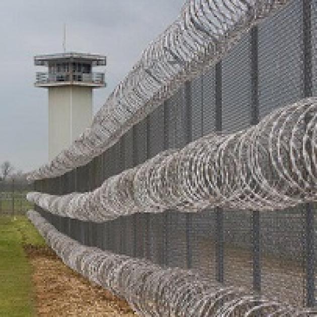 Long barbed wire fence and a tower of a prison