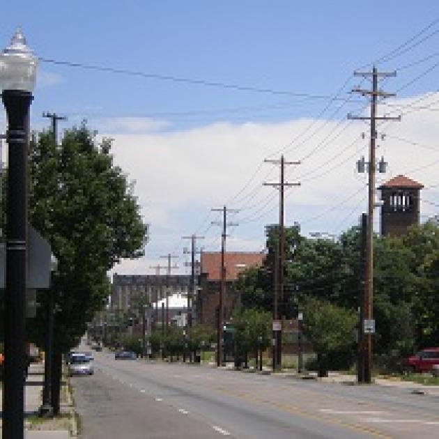 Street scene with a tower and trees and a lightpost and electricity poles