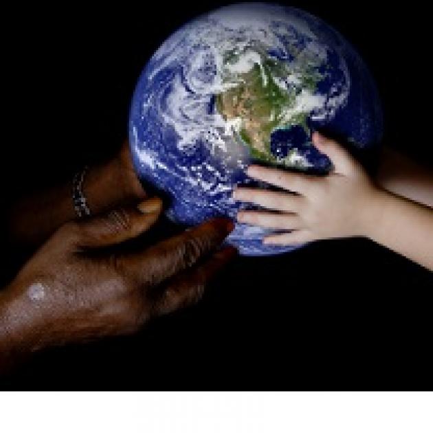 Black hands at left and white hands at right both holding an Earth globe in the middle