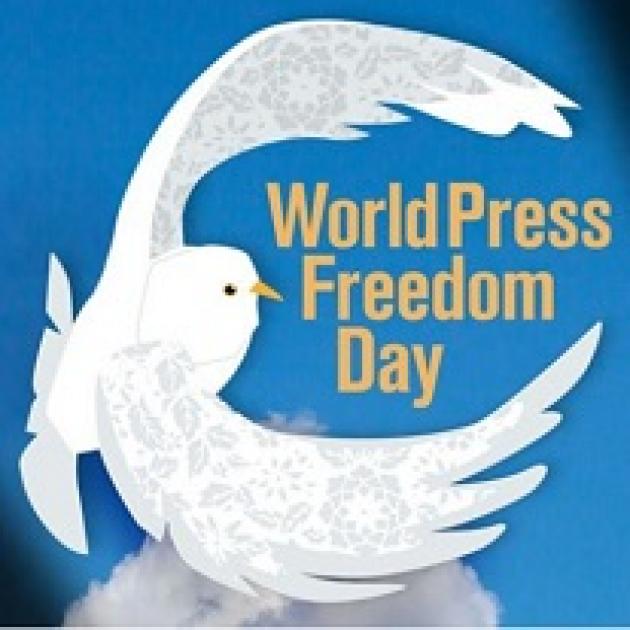 Bright blue background and drawing of white dove with wings encircling the words World Press Freedom Day