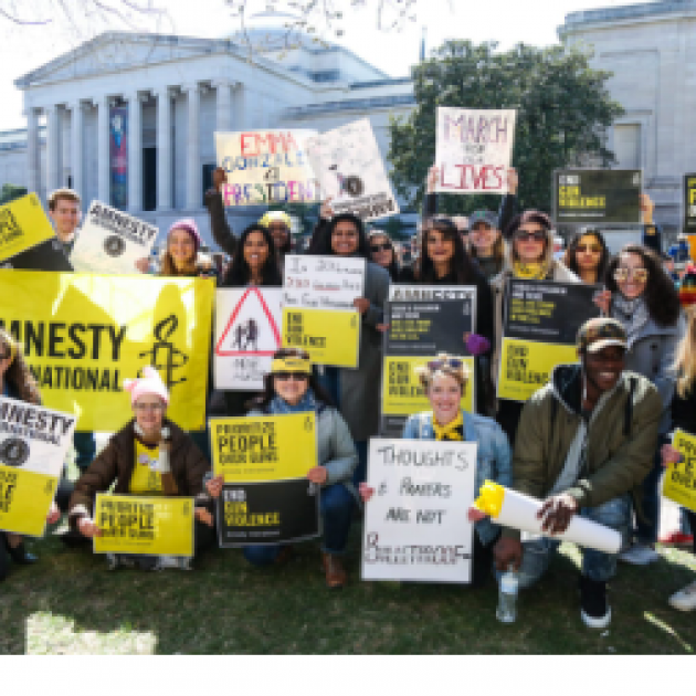 People posing outside with Amnesty signs
