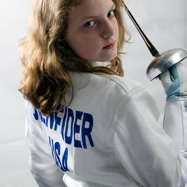Very young blonde girl looking tough holding a sword