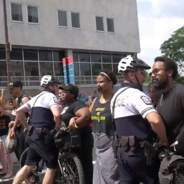 Police al suited up with helmets and bikes attacking stationary black people with black tape over their mouths