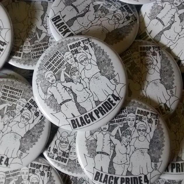 Pile of white and black buttons with drawing of four black kids raising fists on them