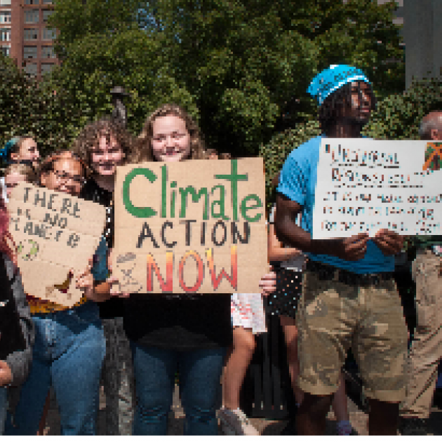 People holding signs at climate strike saying Climate Action Now