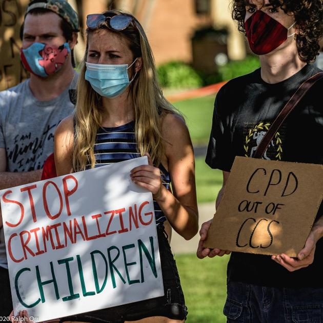 People holding signs saying Stop Criminalizing Children