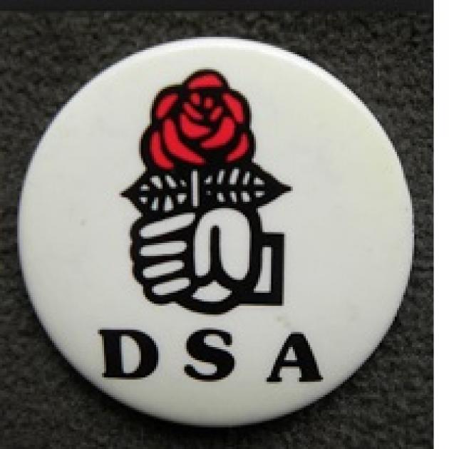 white button with fist holding rose logo and letters DSA