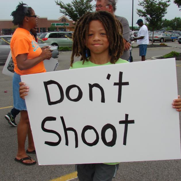 Boy holds sign that says Don't Shoot