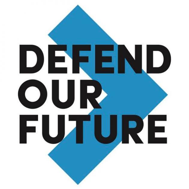 Big blue arrow head pointing right with black words on top Defend our future