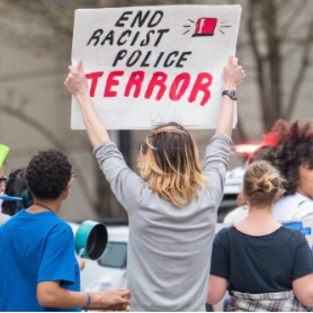 Woman holding sign saying End Racist Police Terror