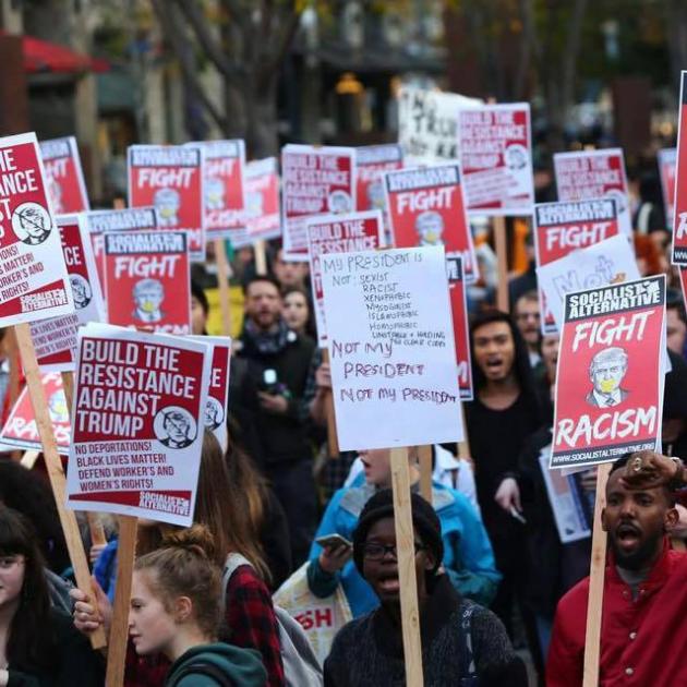 Lots of people holding Fight Racism signs