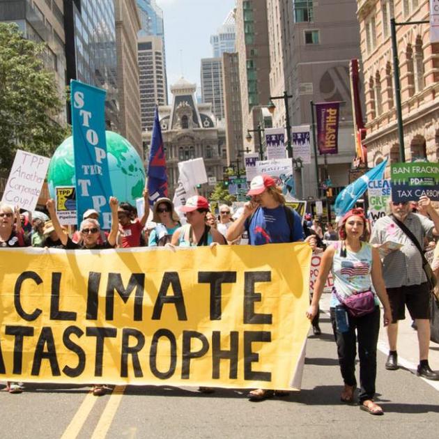 People marching with large banner about climate catastrophe
