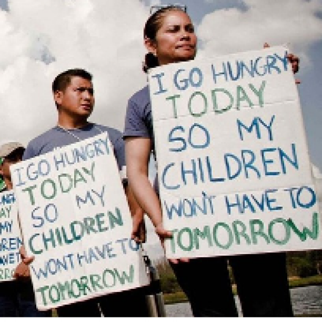 Two Latino people holding signs saying I go hungry so my children won't have to tomorrow