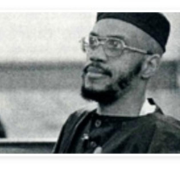 Black and white photo of black man in muslim outfit, glasses and a beard