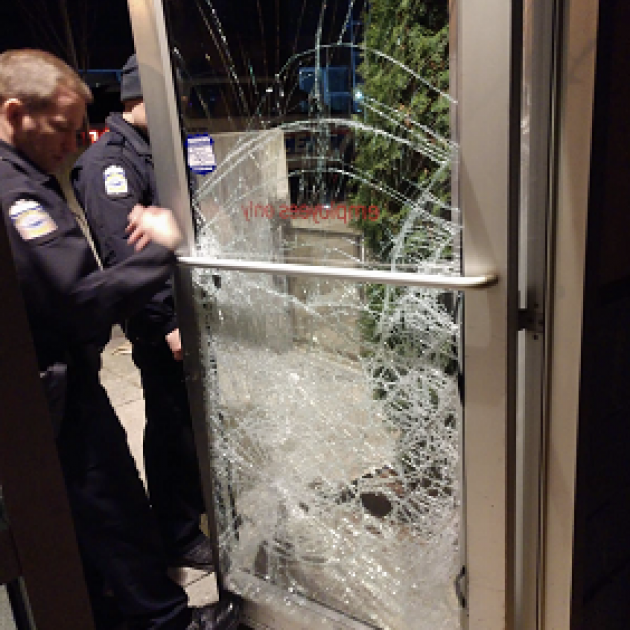 Shattered glass door and policemen