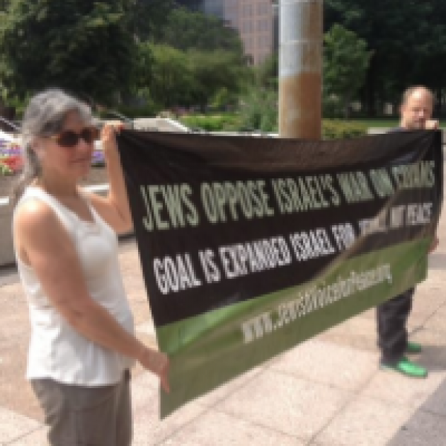 Two people holding a banner saying Jews Oppose Israel