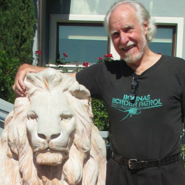 Jim Heddle standing next to a lion statue
