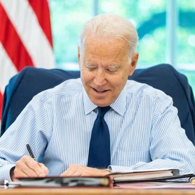 Joe Biden at desk signing something