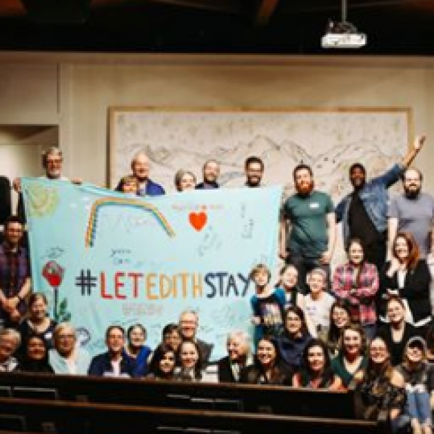People posing with a sign saying Let Edith Stay