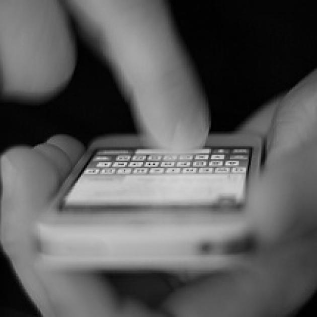 Hand typing onto a cellphone