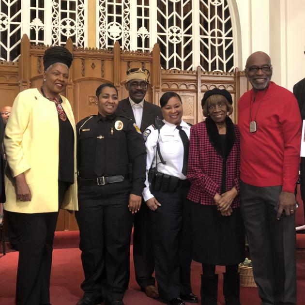 Several black men and women posing at a church 