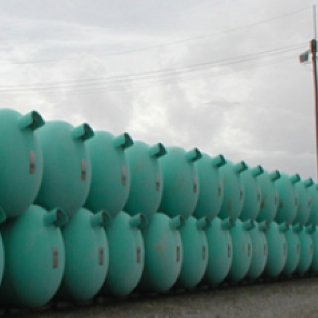 Dozens of blue green barrels lined up