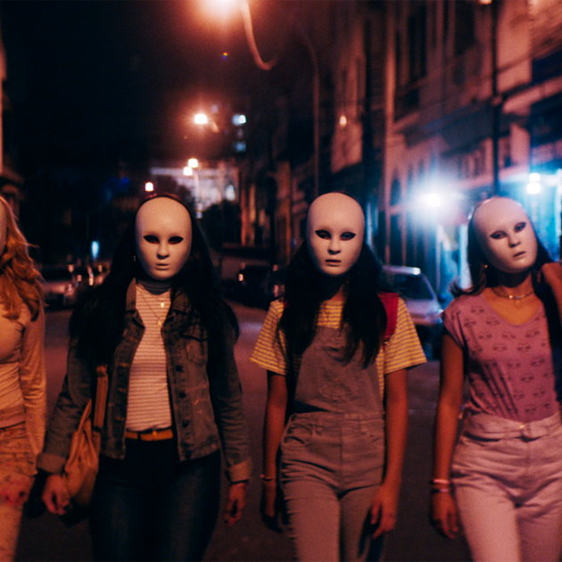 Women walking at night wearing masks