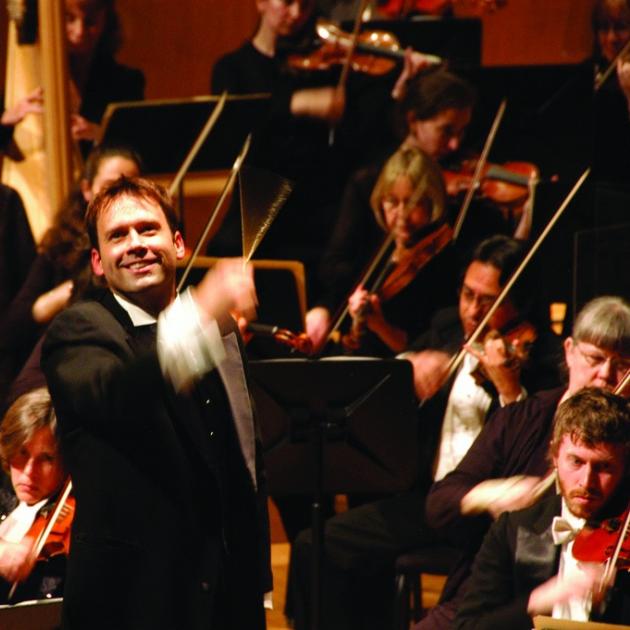 Man in front of orchestra conducting