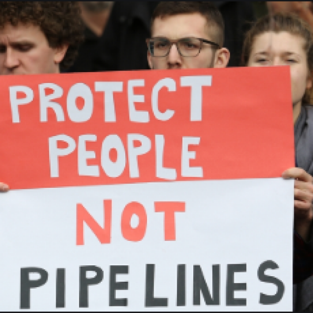 Demonstrators holding a sign that reads Protect People not Pipelines