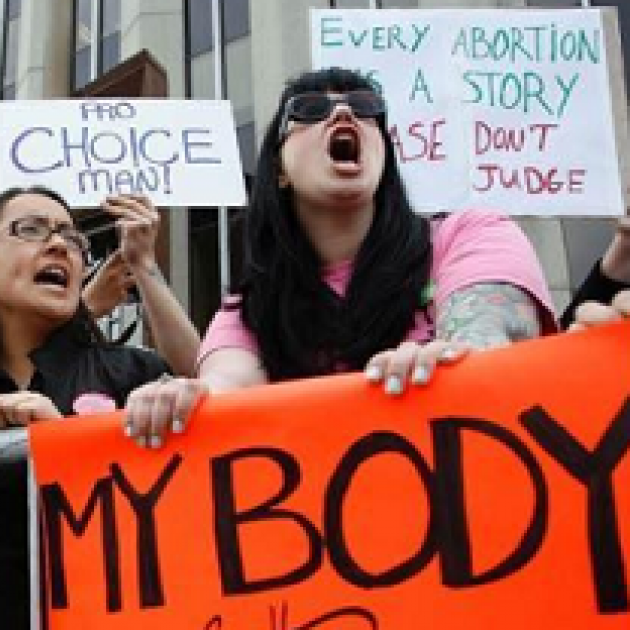 Women outside yelling at a protest with signs that say My Body My Choice