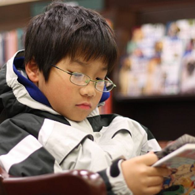 An asian boy reading GRAPHiC N0VEL in a Barnes & Noble bookstore in West Hartford, Connecticut