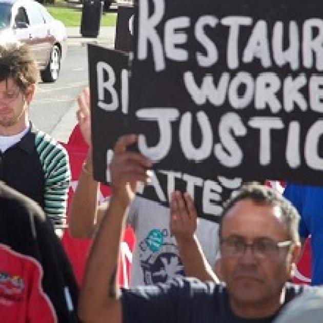 People protesting with sign Restaurant worker justice