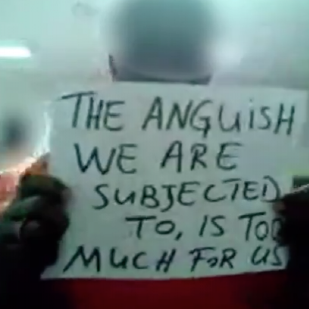 An inmate holding a sign saying The Anguish we are subjected to is too much for us