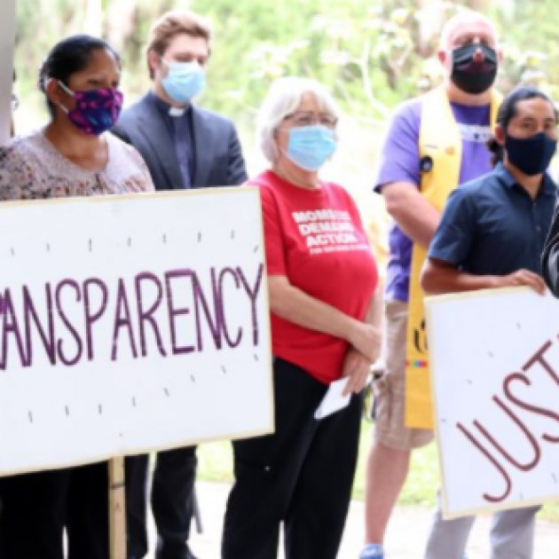 People with signs saying Transparency and Justice