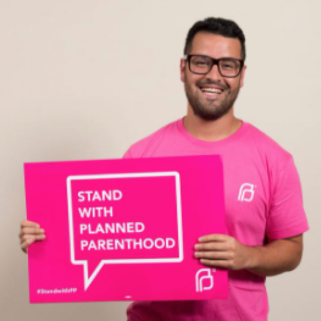 Man holding a sign saying Stand with Planned Parenthood