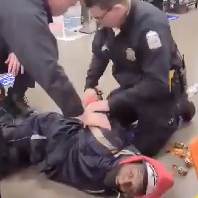 Cops holding a black man down