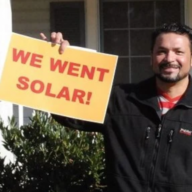 Guy holding sign saying We Went Solar