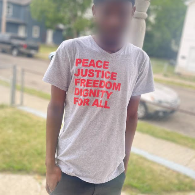 Man in T-shirt saying Peace, Justice, Freedom, Dignity for all
