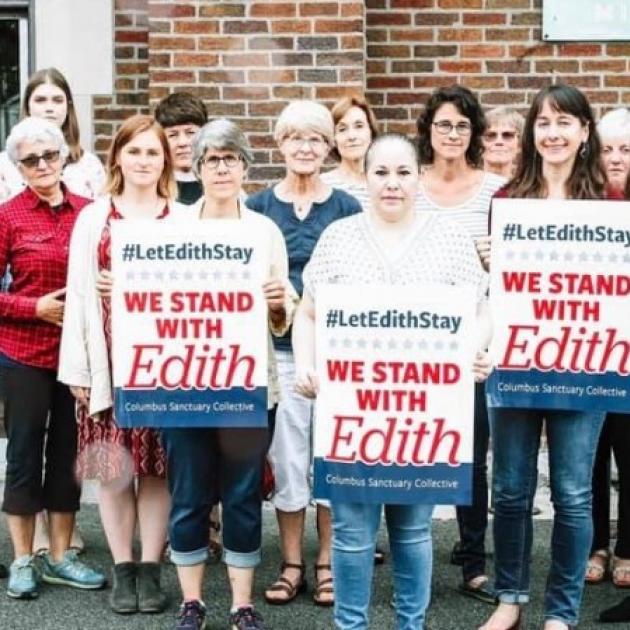 People holding signs saying We Stand with Edith