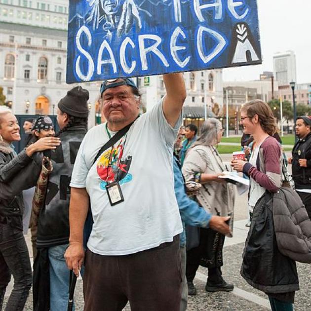 Native man holding sign about Standing Rock