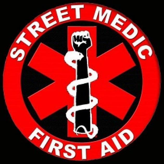 Red circle with star shape in middle with fist and snake, words Street Medic First Aid