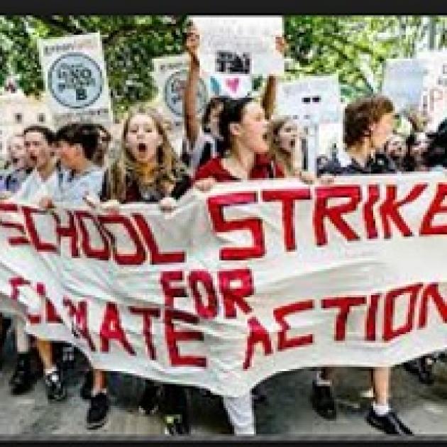 Young people marching outside with a banner reading School Strike for Climate Action